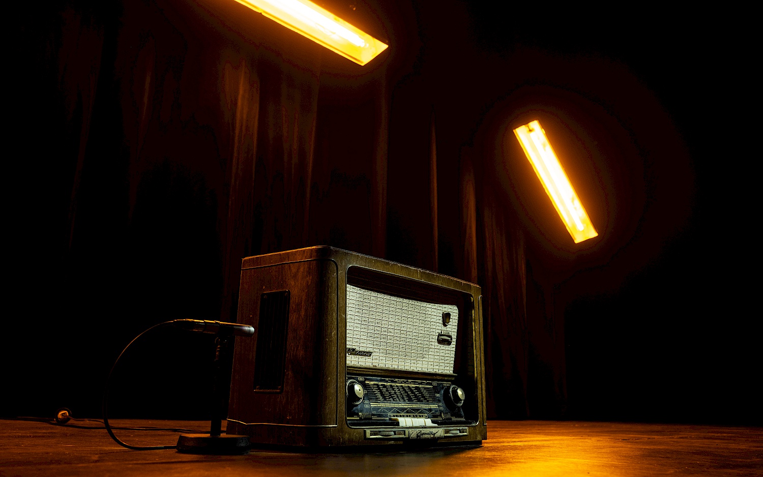 Ein altes Radio auf einer Bühne, von Scheinwerfern beleuchtet.