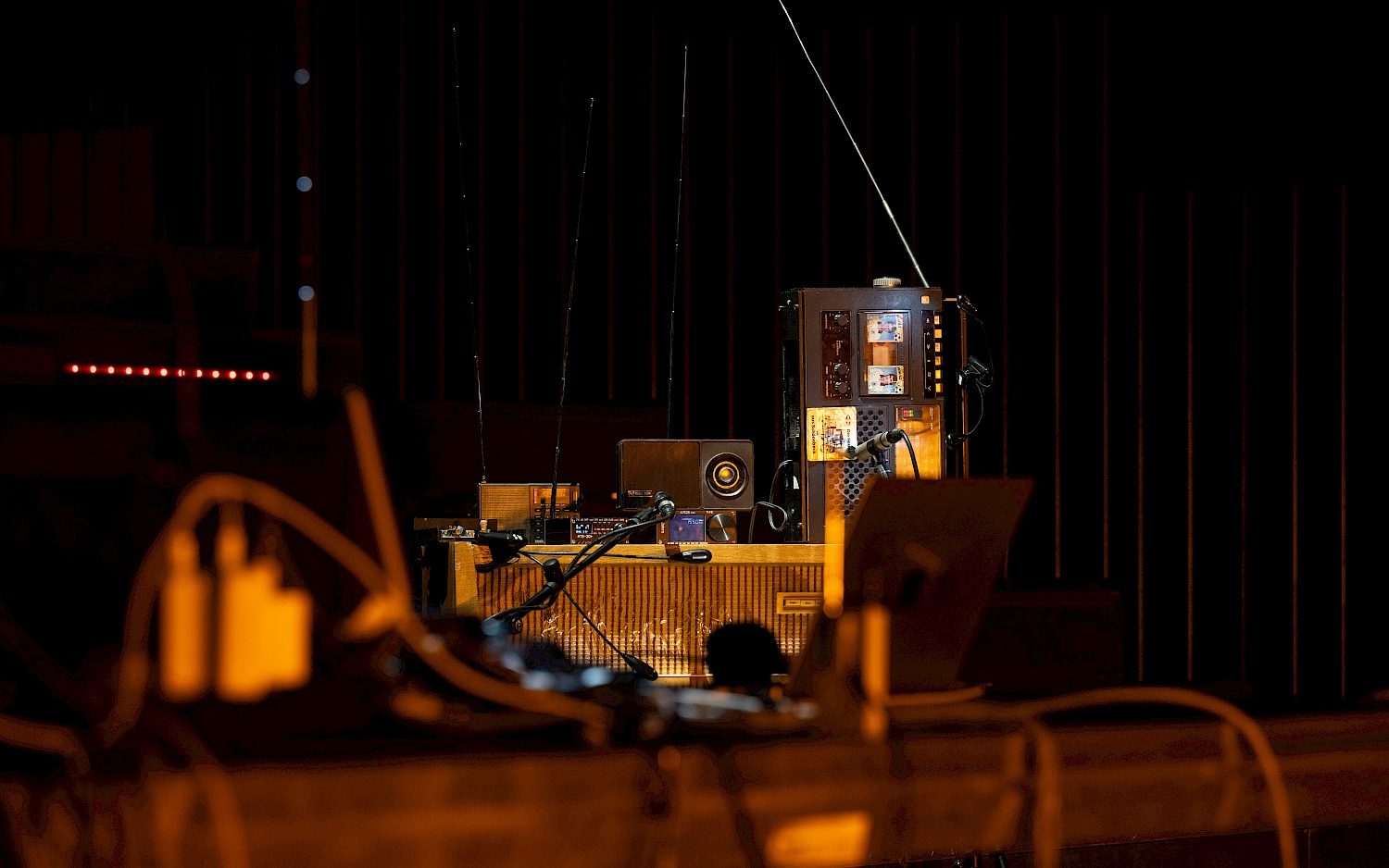 Radio-like machine in front of a microphone on stage.