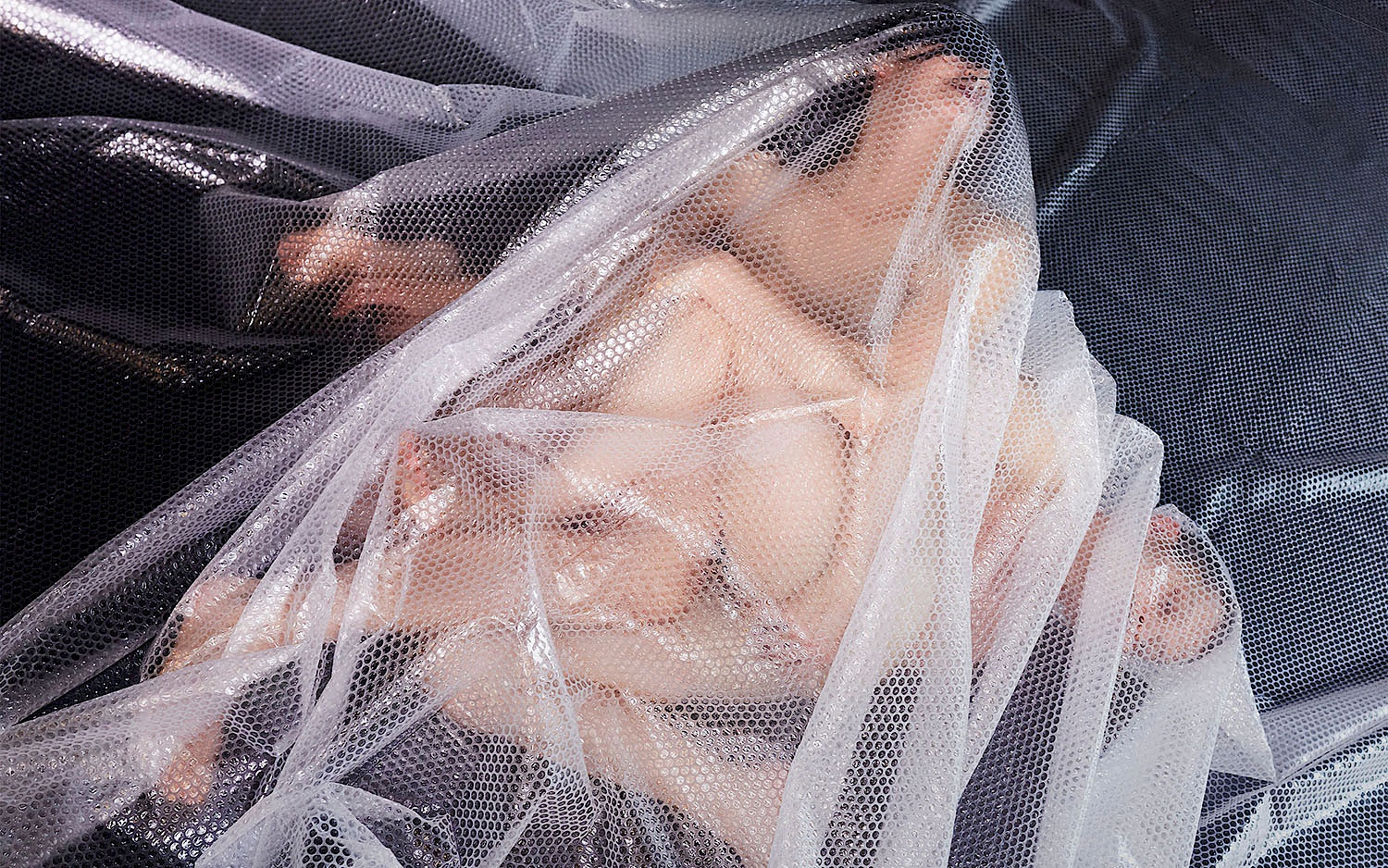 Foto: Piet Truhlar Zwei scheinbar nackte Personen liegen verknotet unter einer Plastikfolie.