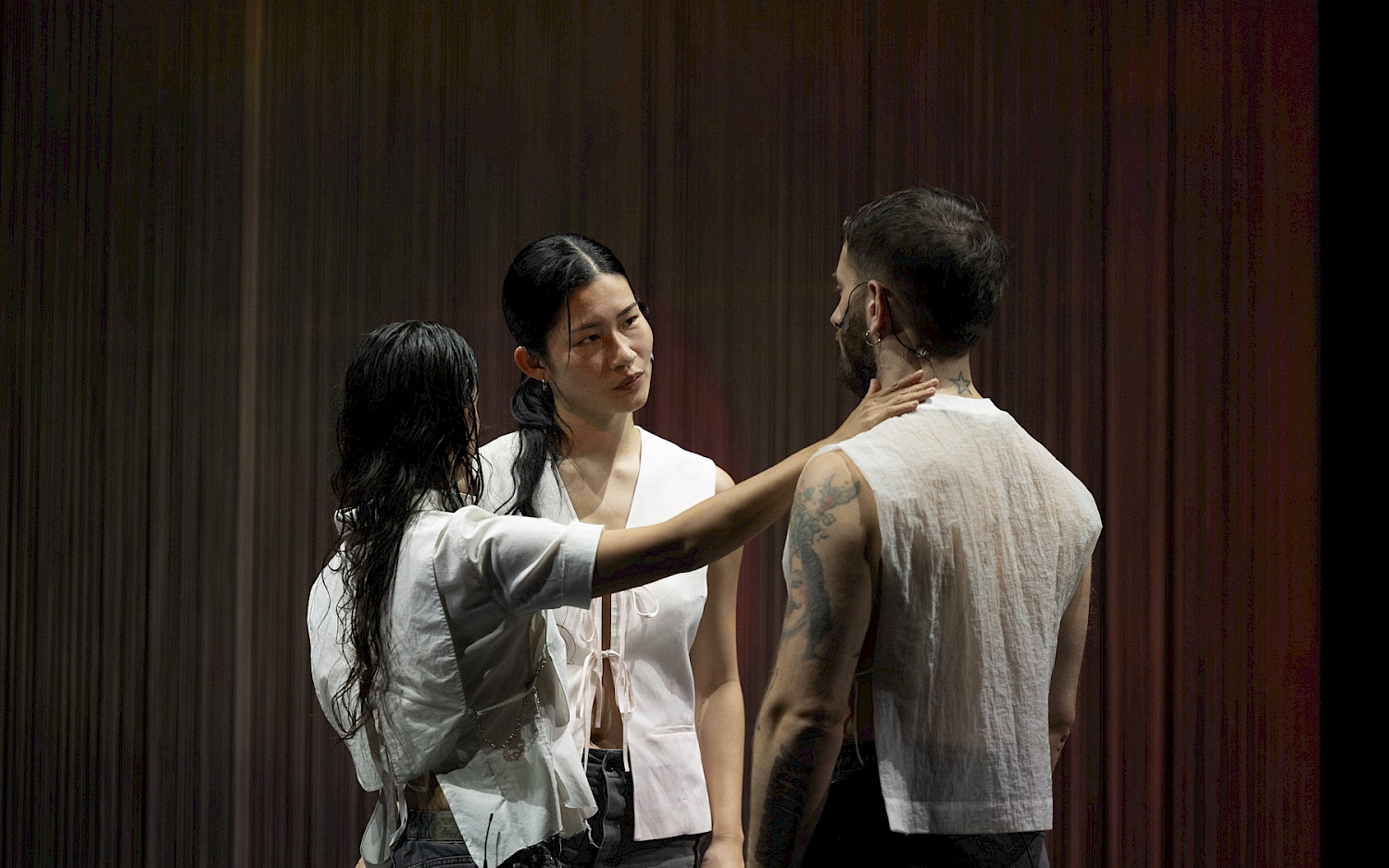 Drei Tänzer*innen im Kreis beieinander stehend.