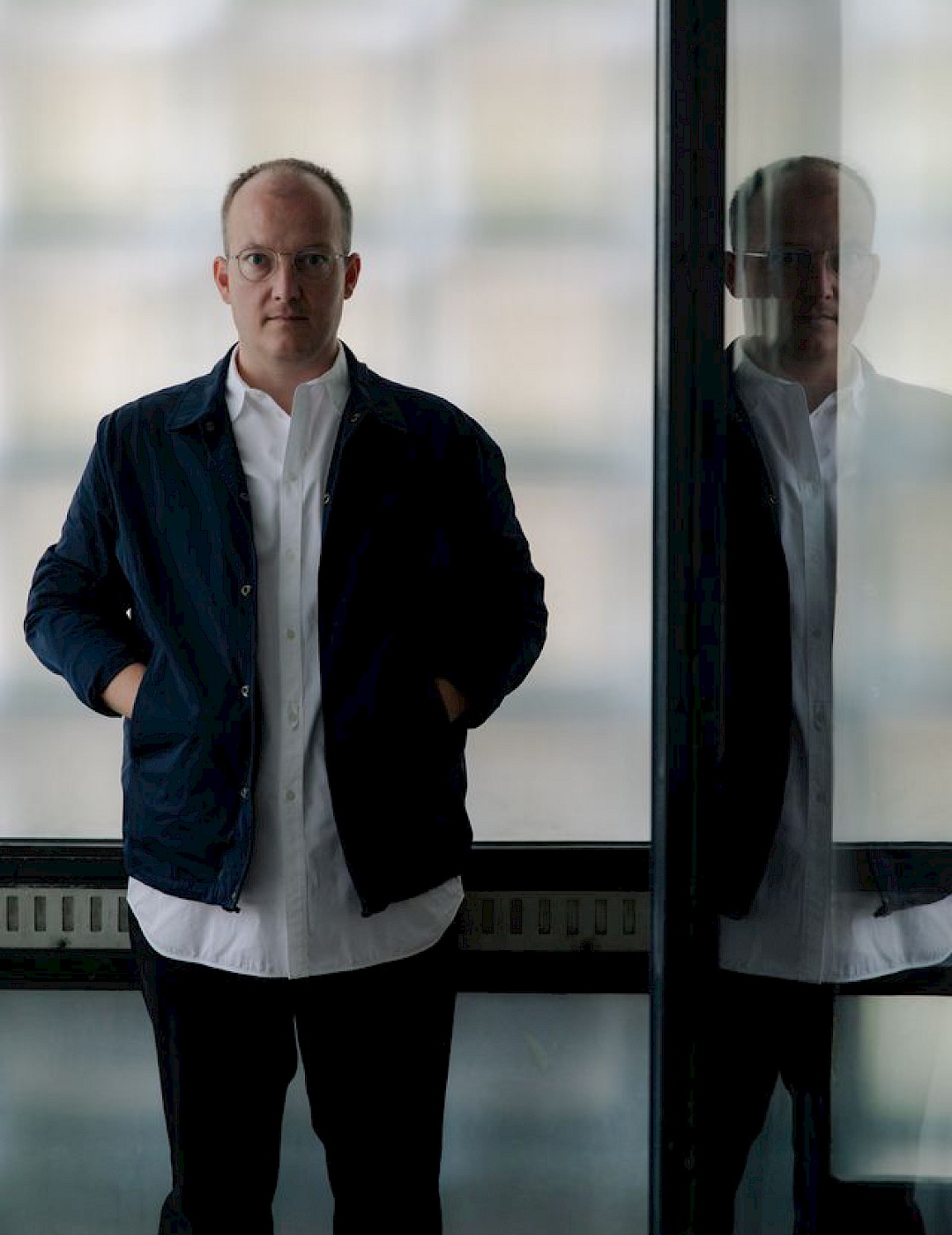 Fabian Schöneich steht vor einer Glasfront