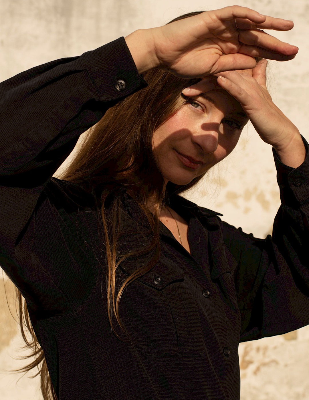 Kara-Lis Coverdale shields her face from the sun with her hands.