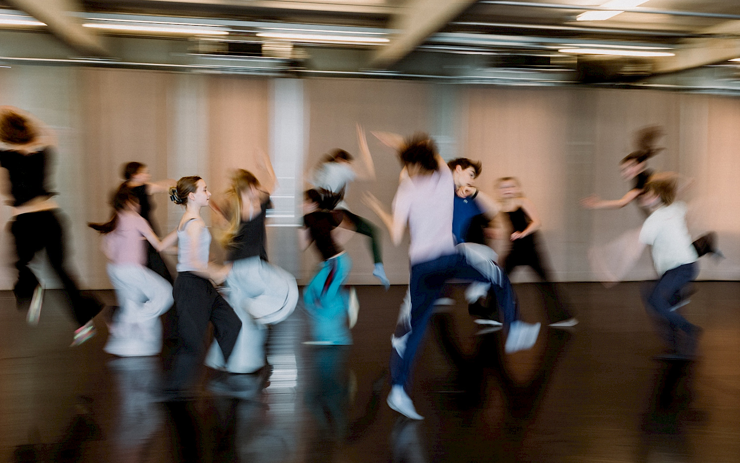 Eva Radünzel a group of dancers moving swiftly in the studio