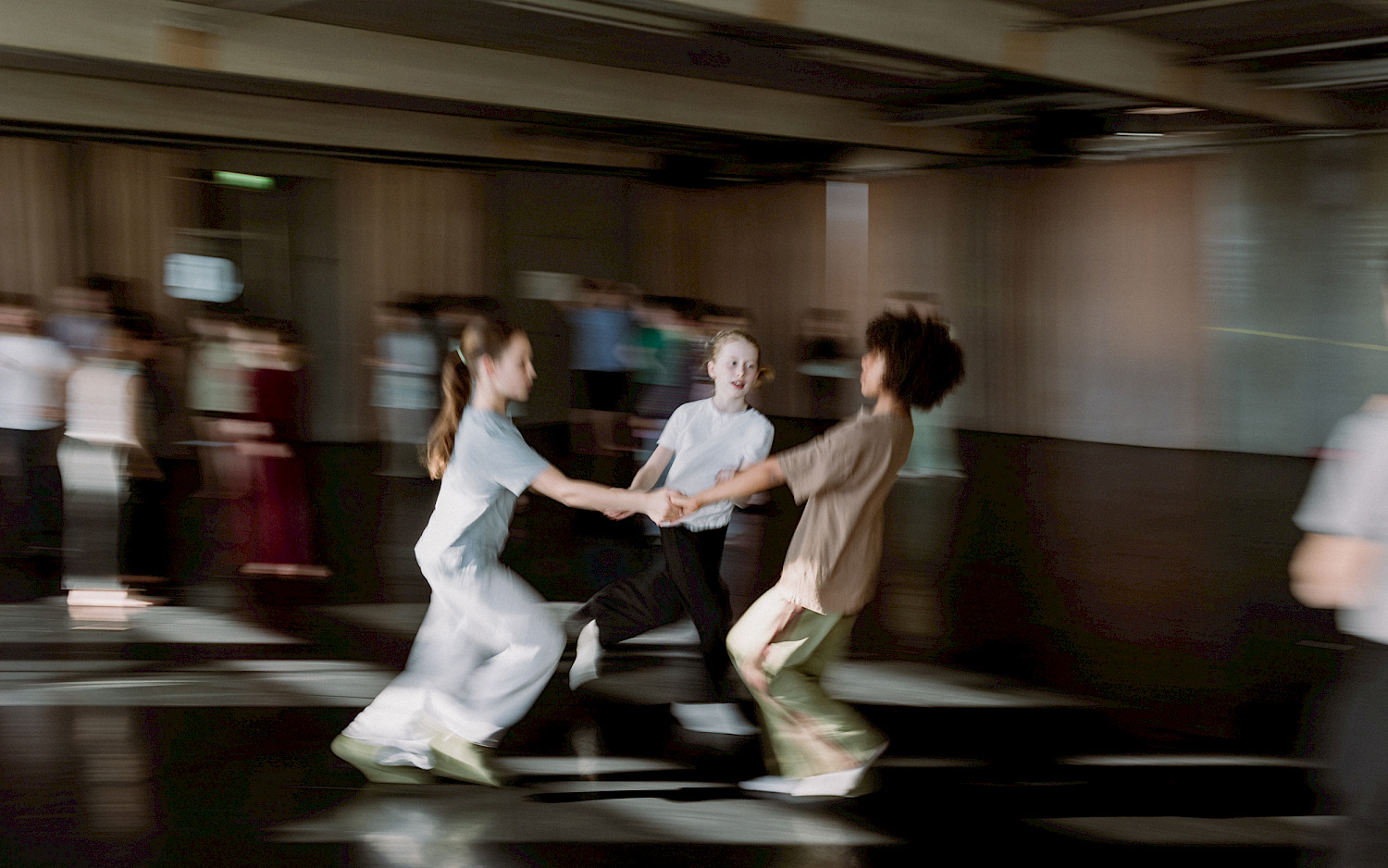 Eva RTadünzel Three people are spinning in a circle as they dance