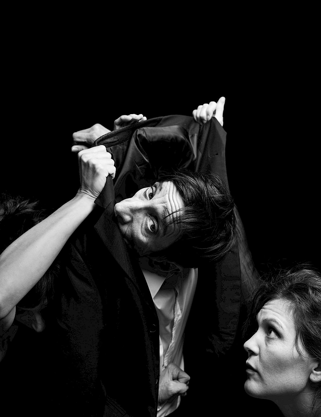 Phil Dera A black-and-white photograph of two performers, one of whom is wrapped in a jacket.