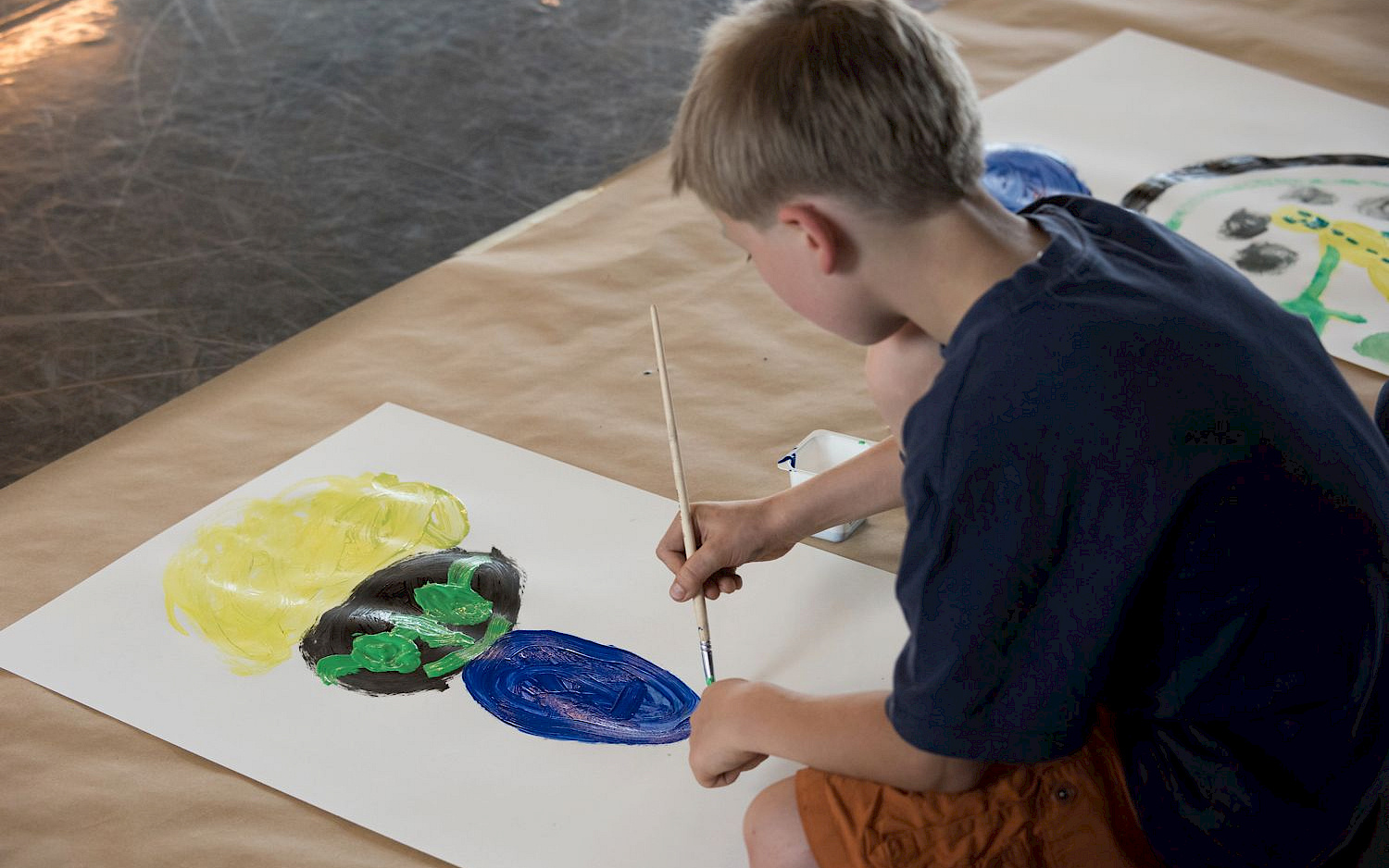 Giacomo Cosua A child paints a picture.