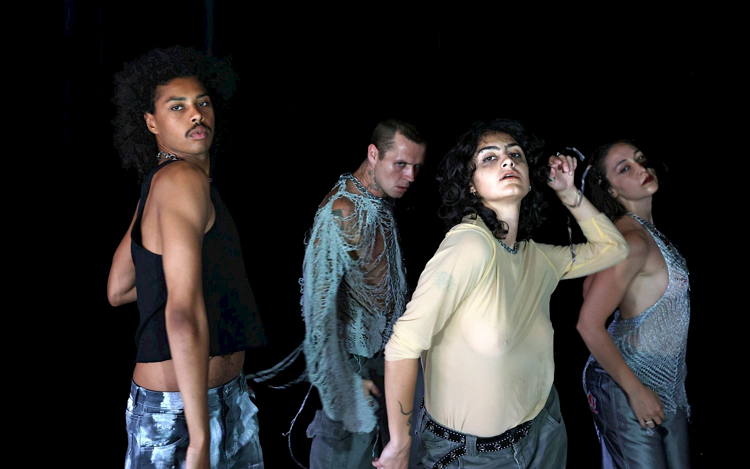 Dorothea Tuch Vier Performer*innen vor schwarzem Hintergrund, tanzend.