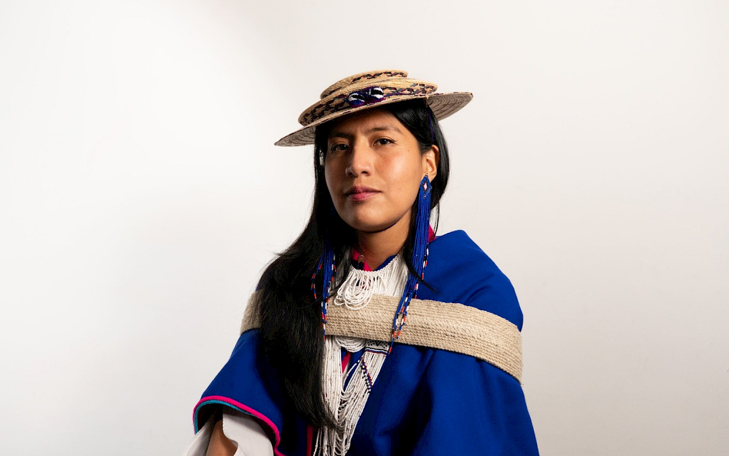 Julieth Morales Porträt von Julieth Morales in blauer traditioneller Kleidung mit Hut vor hellem Hintergrund