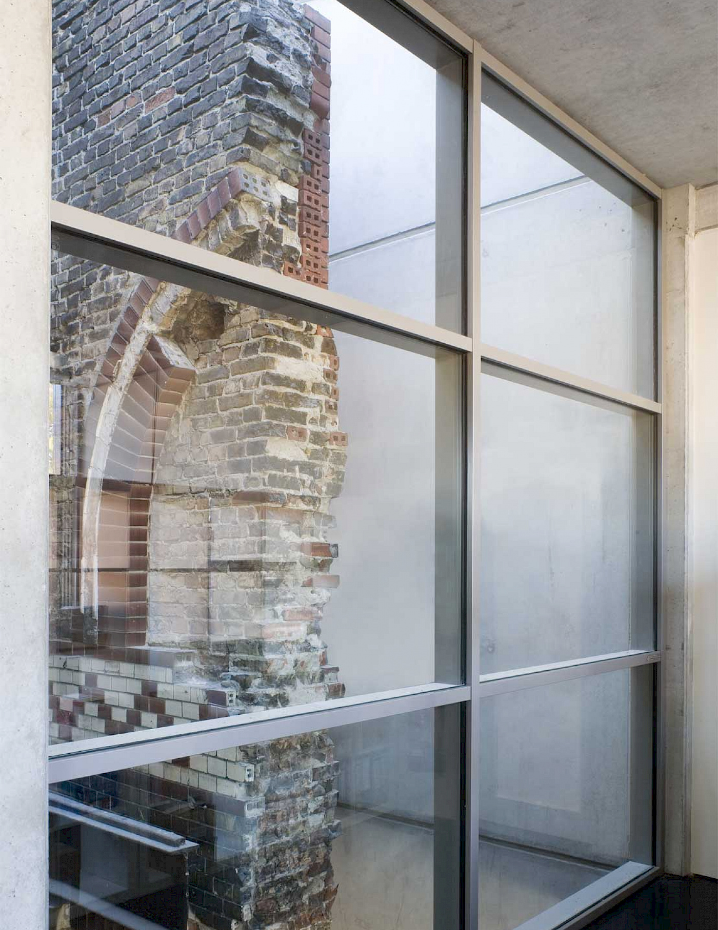 Historisches Mauerwerk hinter modernen Fenstern