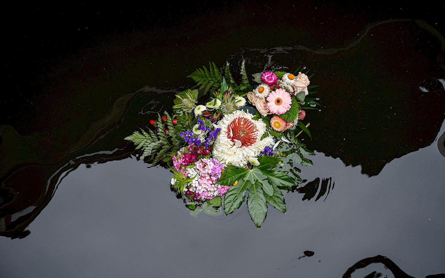 Ein buntes Blumengesteck schwimmt auf der Spree.