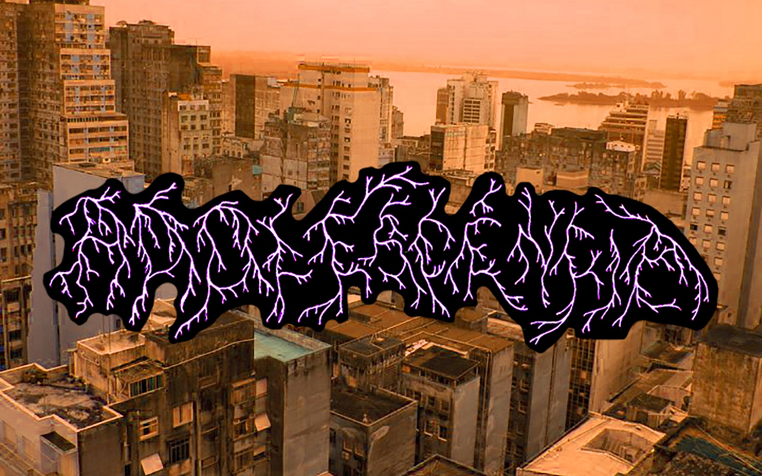 Visual Adolescência: A city with many skyscrapers bathed in red evening light, with graphic lettering in purple on top.