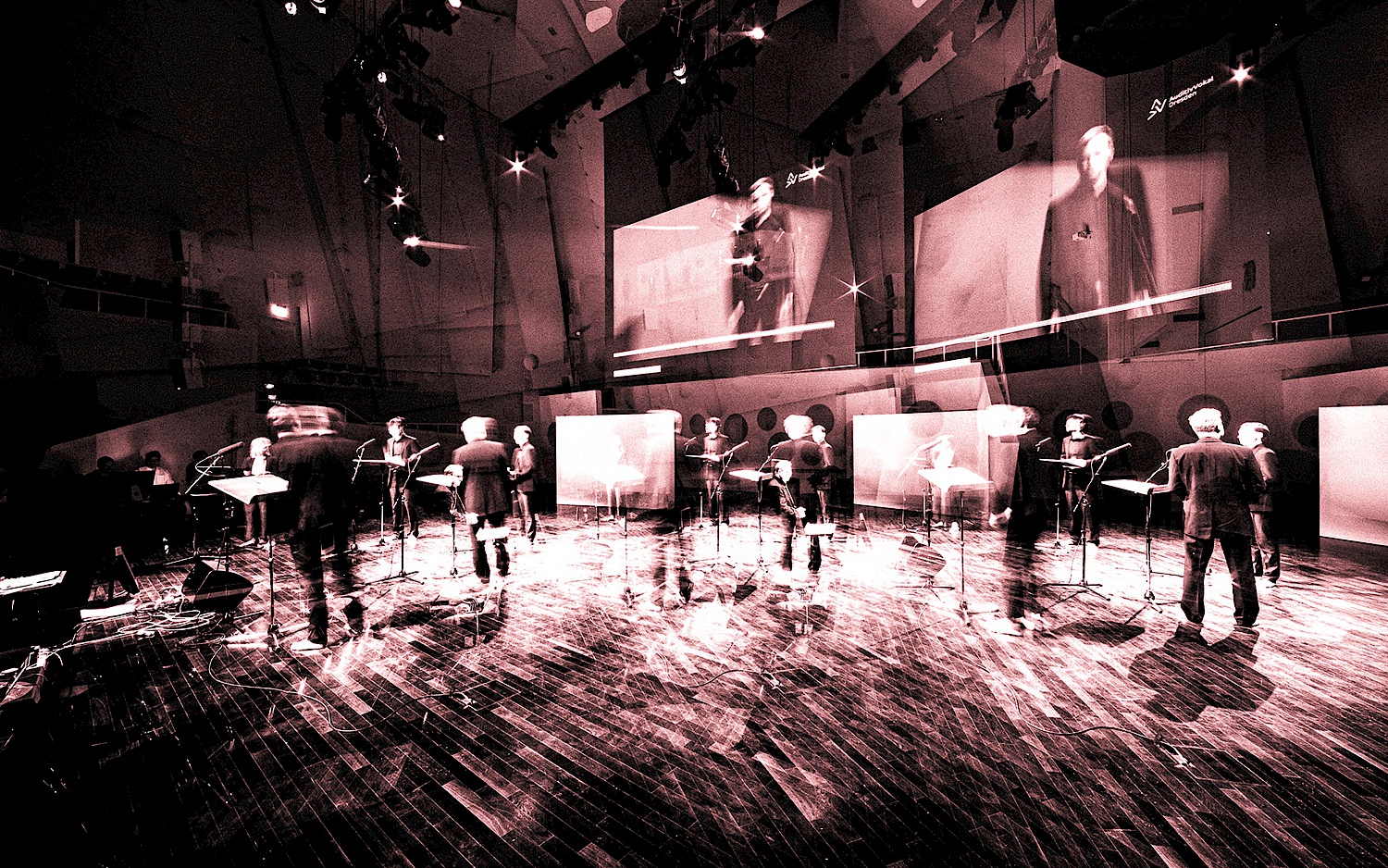 Verschwommene schwarz-weiß Aufnahme des Ensembles auf der Bühne.