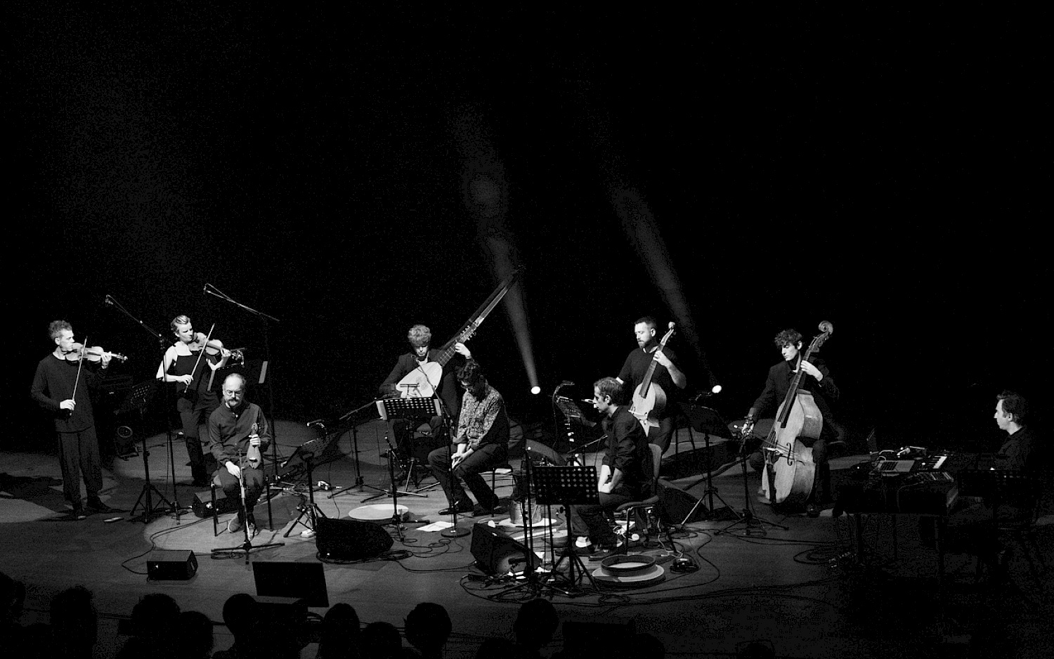 Black and white picture of all the instrumentalists of "Isles & Rivers" on stage.